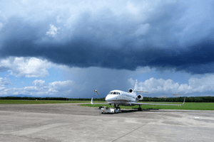 flugzeug auf rollfeld vor dunklen wolken